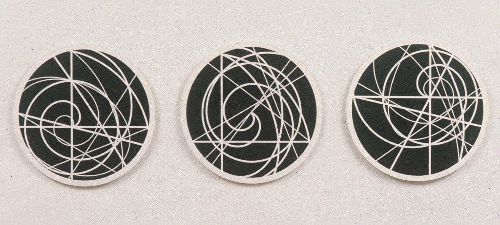 Three circular paintings with white lines on them.
