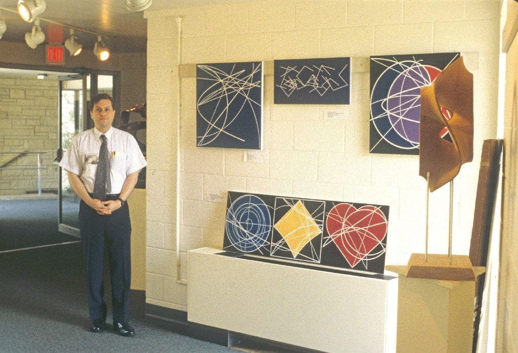 A man standing in front of some paintings