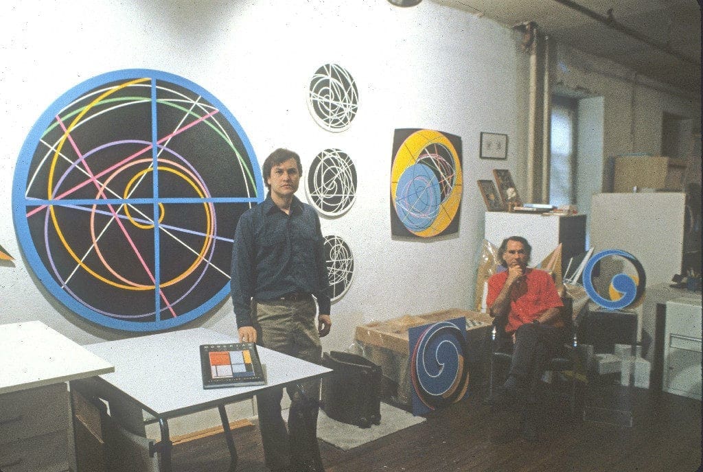 A man standing in front of some paintings