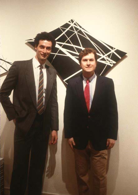 Two men in suits posing for a picture.