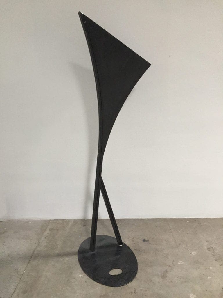 A black metal sculpture sitting on top of a floor.