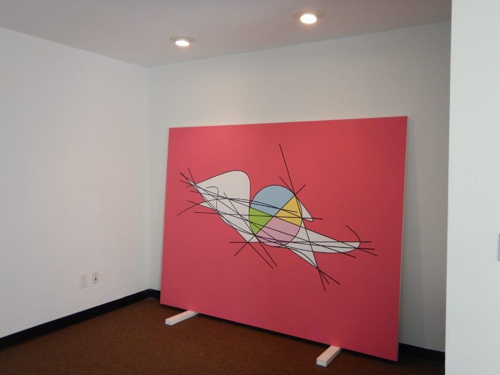 A large painting of an abstract bird on the wall.