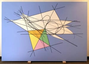 A painting of a colorful geometric design on the wall.