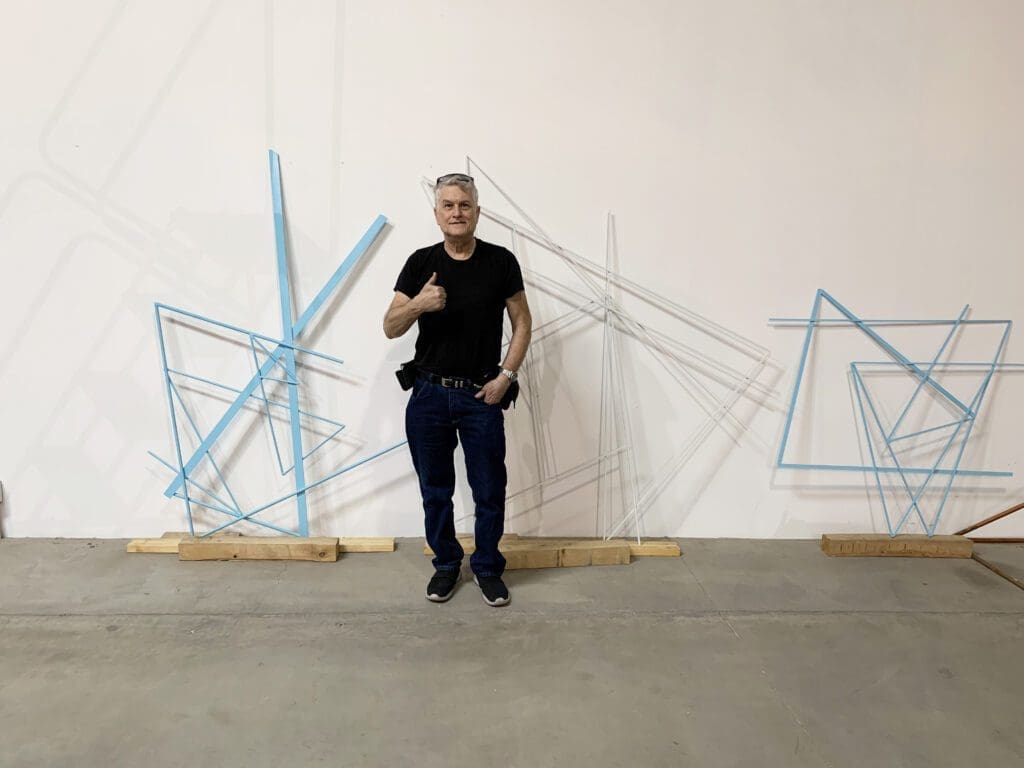 A man standing in front of some wall art