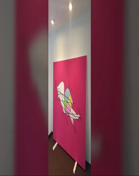 A pink wall with a painting of a bird on it.
