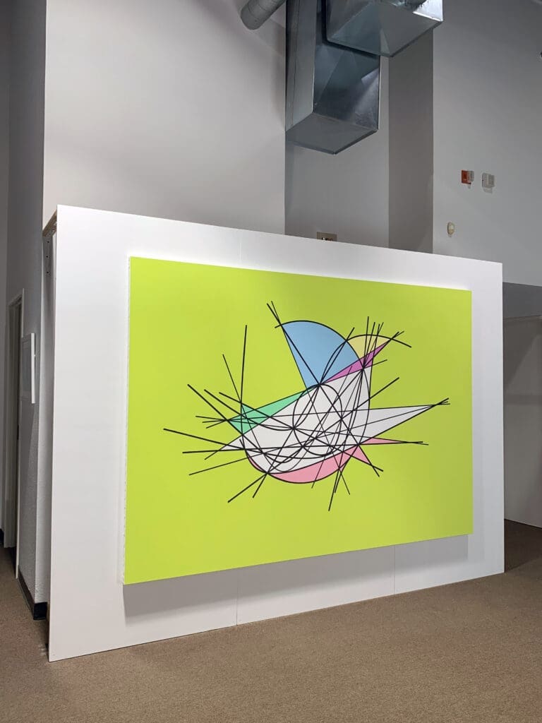 Abstract wall art with geometric shapes and bright colors.