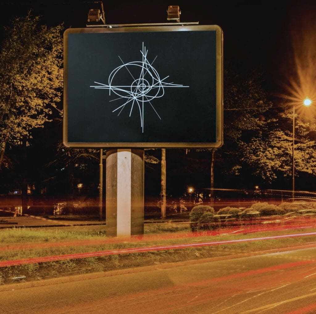 A chalk-drawn compass on a blackboard outdoors at night.