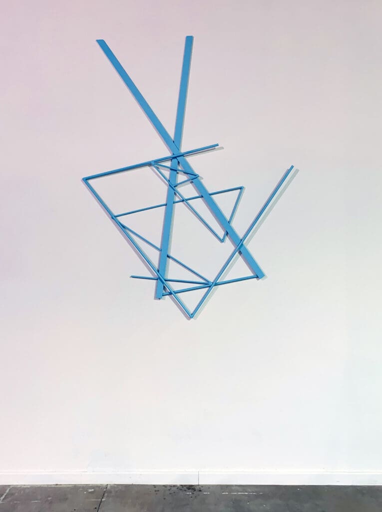 Blue geometric shadows on a white surface.