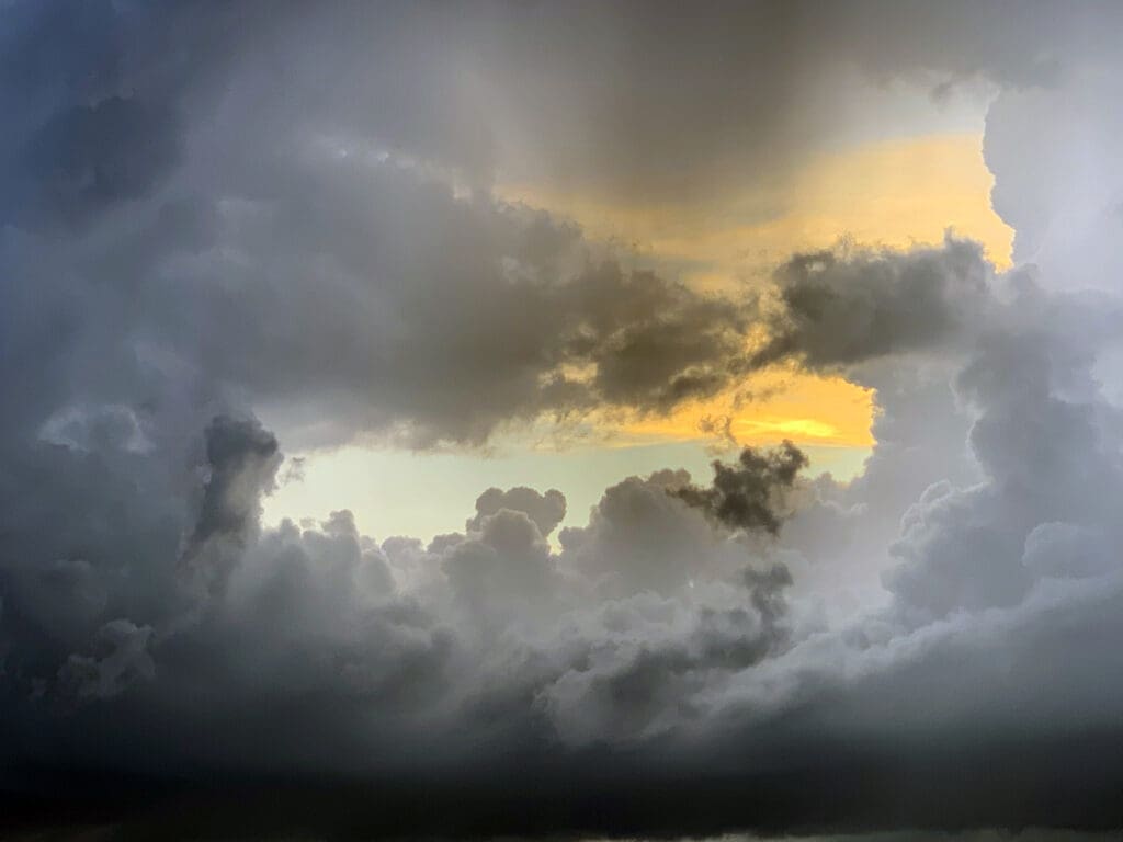 Dark storm clouds with a golden sunset peeking through.
