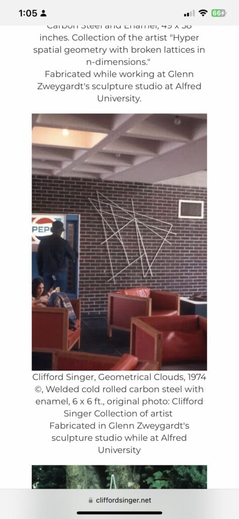 Person standing near a geometric white line design on a brick wall in a room with red chairs.