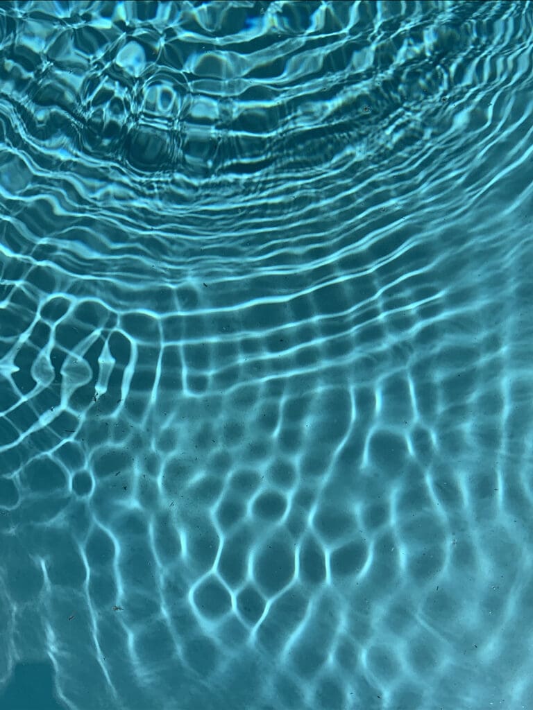 Rippled water surface creating dynamic light patterns.