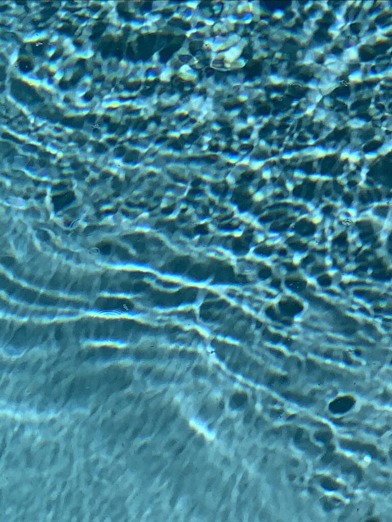 Sunlight reflecting on clear water with gentle ripples.