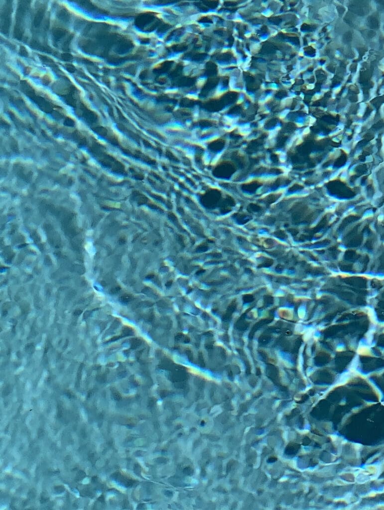 Close-up of water surface with ripples and light reflections.