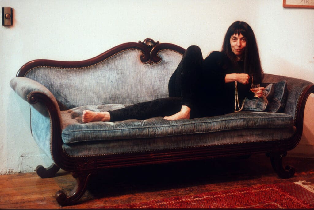 Woman lounging on an antique sofa with a relaxed pose.