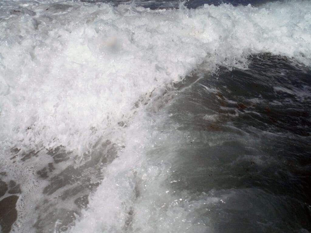 Foamy surf curling over shallow water