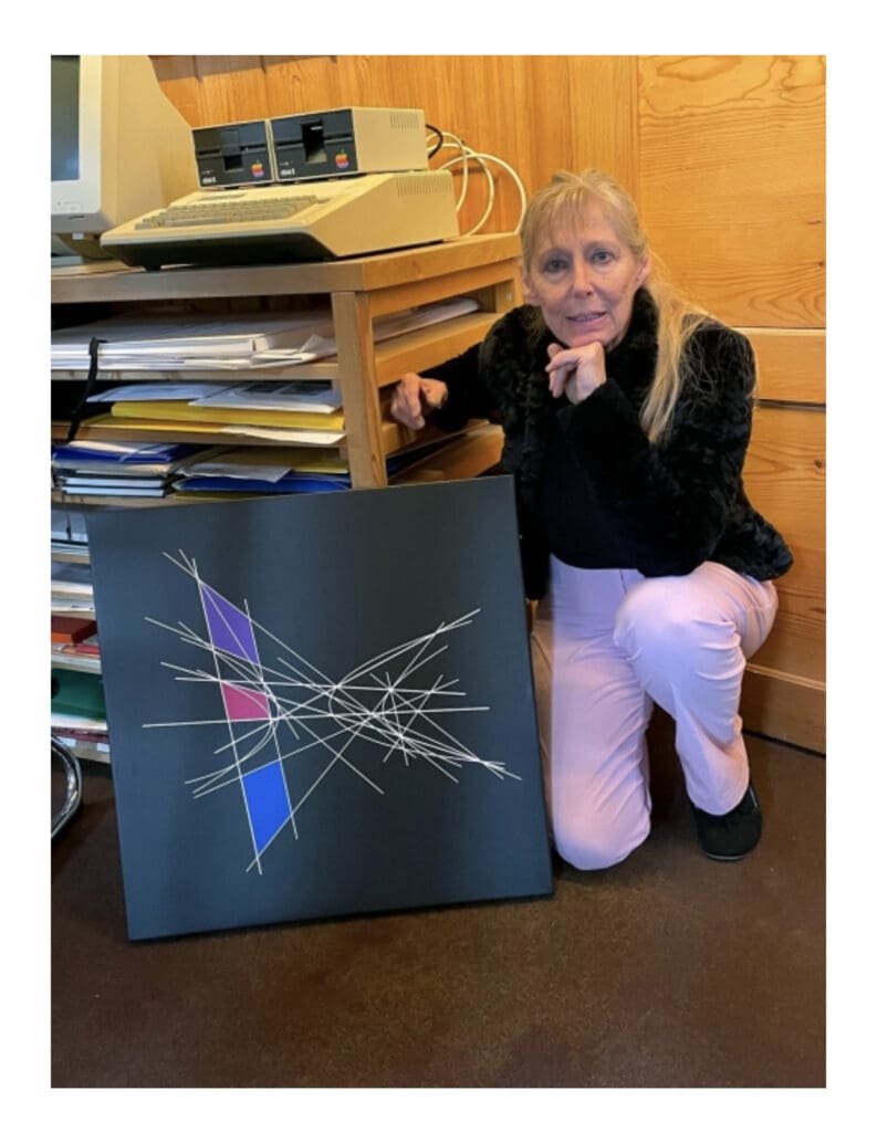 A woman posing with an abstract art canvas in a cozy room.