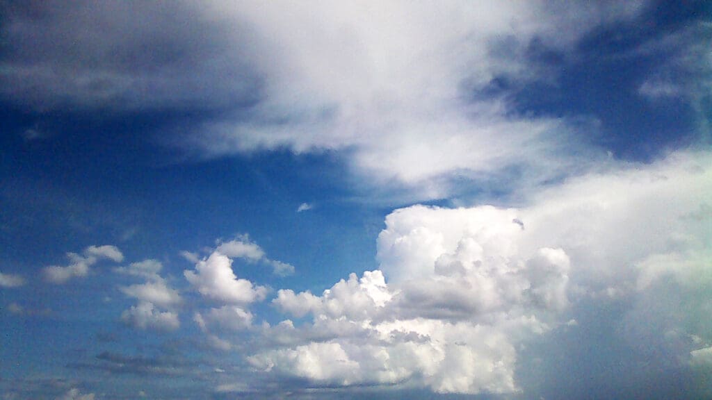 Blue sky with scattered white clouds during the day.