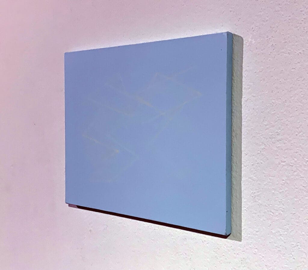 Blue canvas on a textured wall.