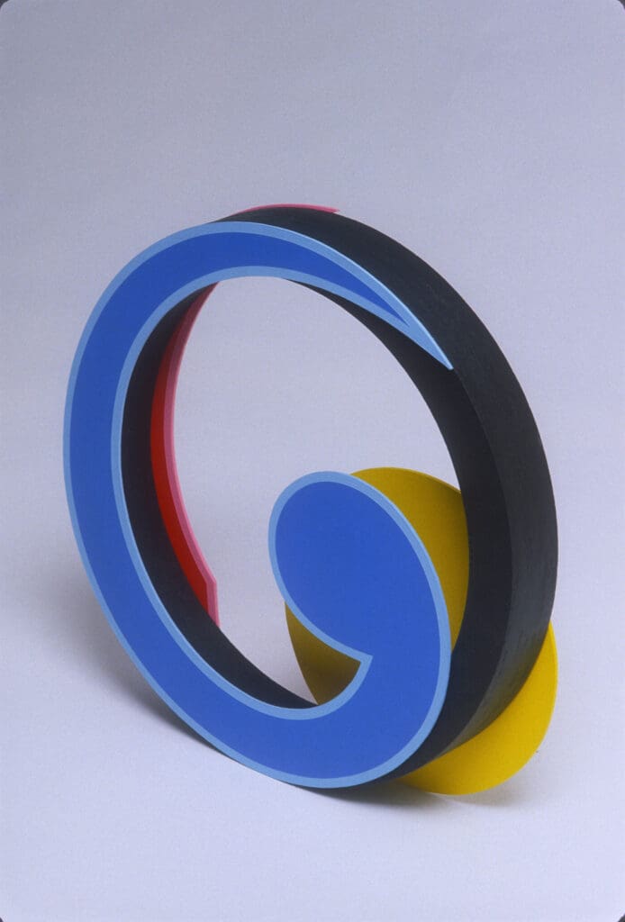 Abstract sculpture with blue, black, and yellow shapes.
