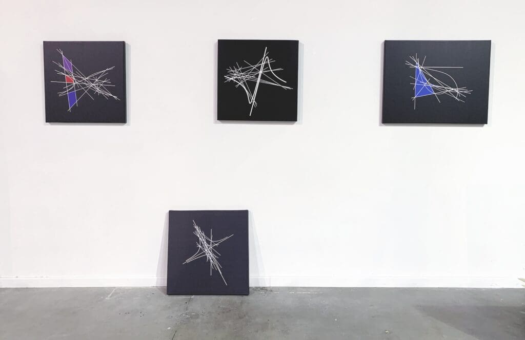 Studio wall with four black canvases