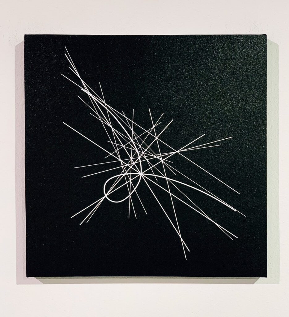 White geometric line pattern on black square panel