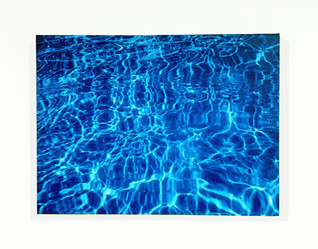 Blue rippling pool water with sunlight reflections