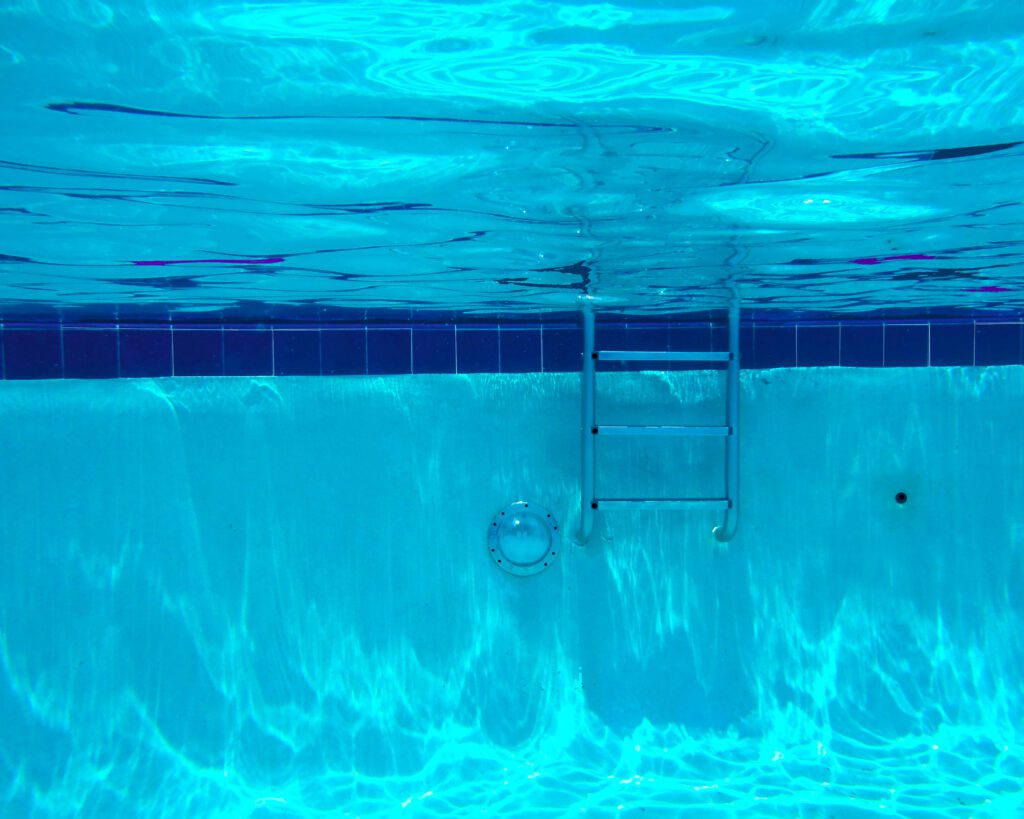 Turquoise underwater view of pool ladder