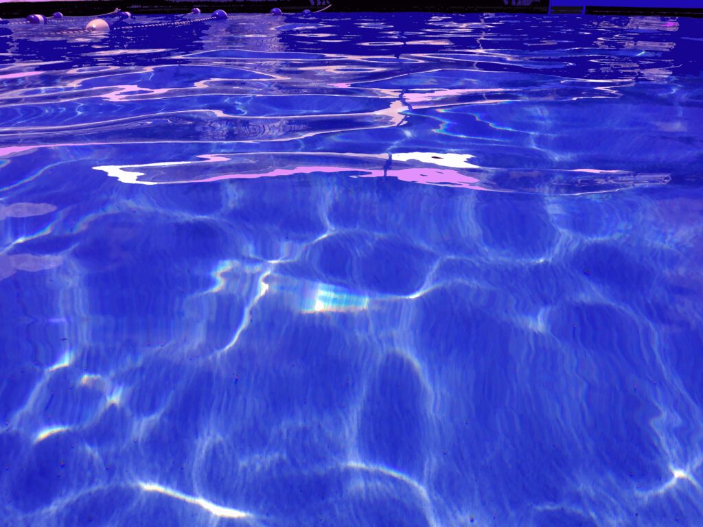 Sunlit pool ripples with pink reflections