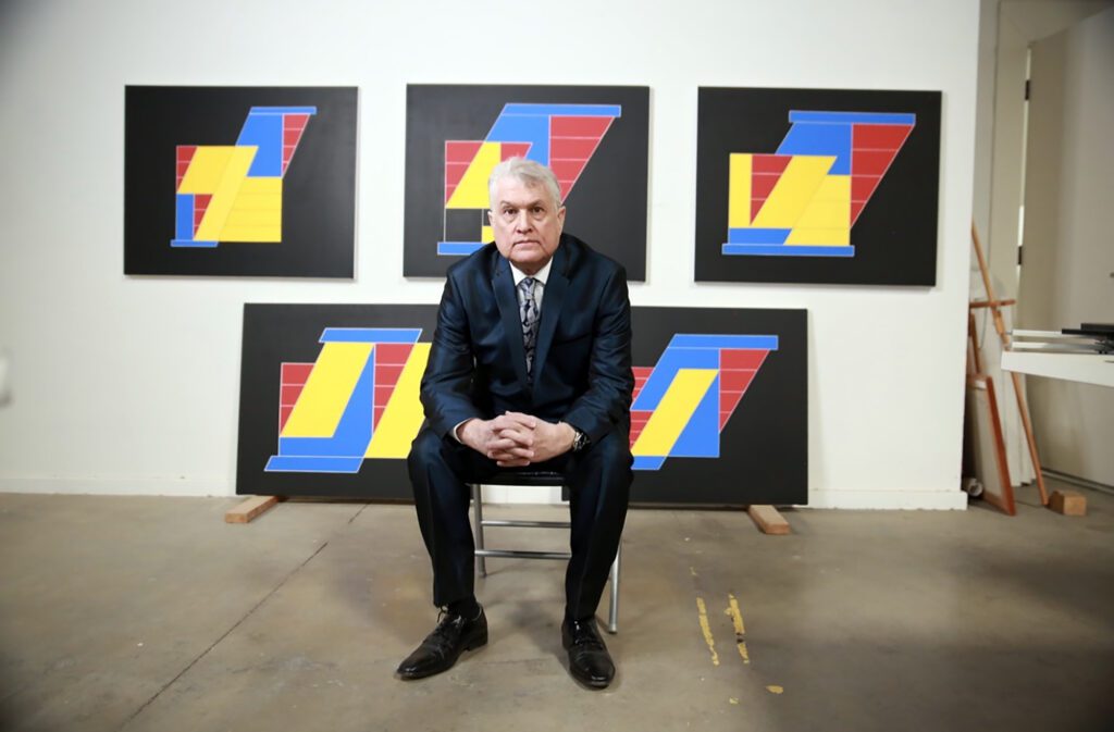 Studio portrait with bold blue yellow paintings