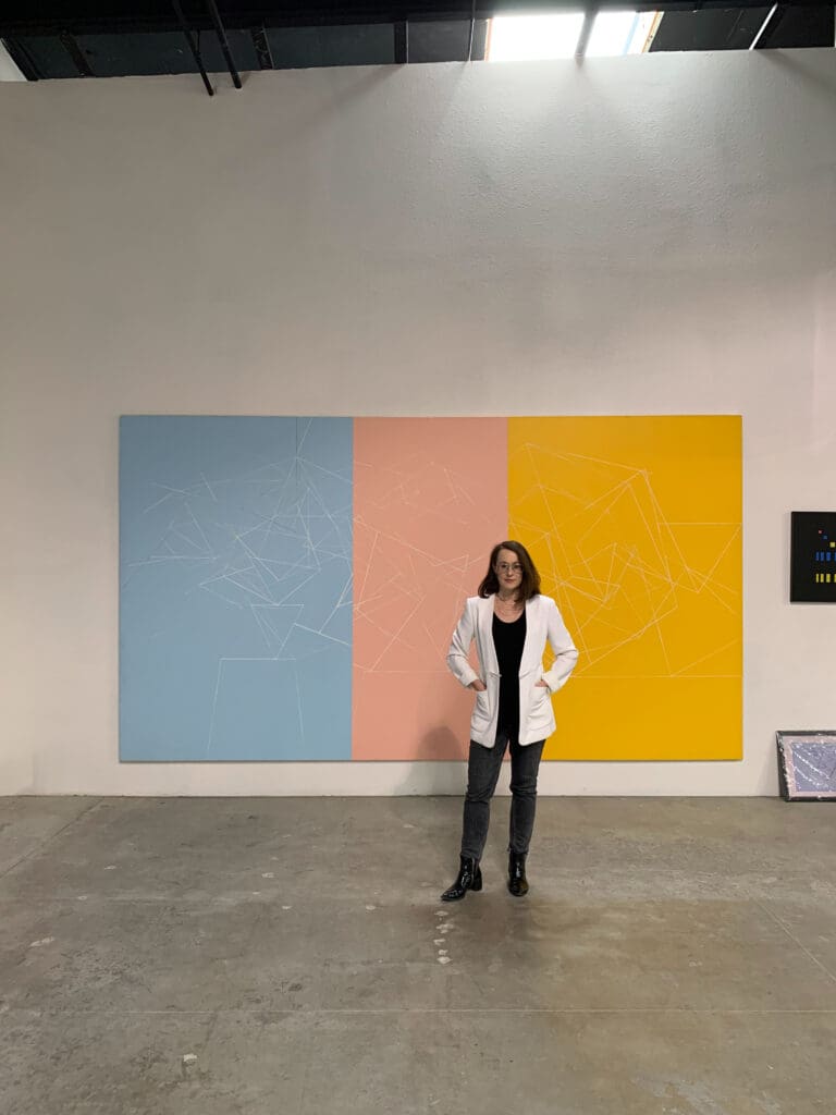 Woman posing in front of colorful geometric panels