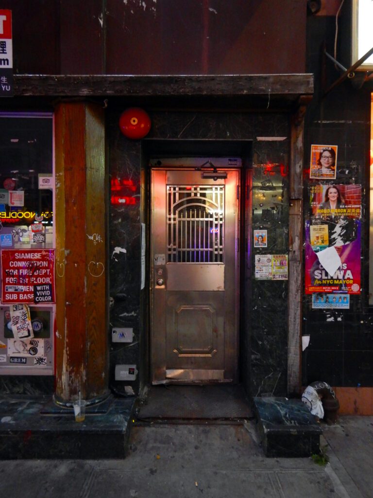 Metal door framed by posters and columns