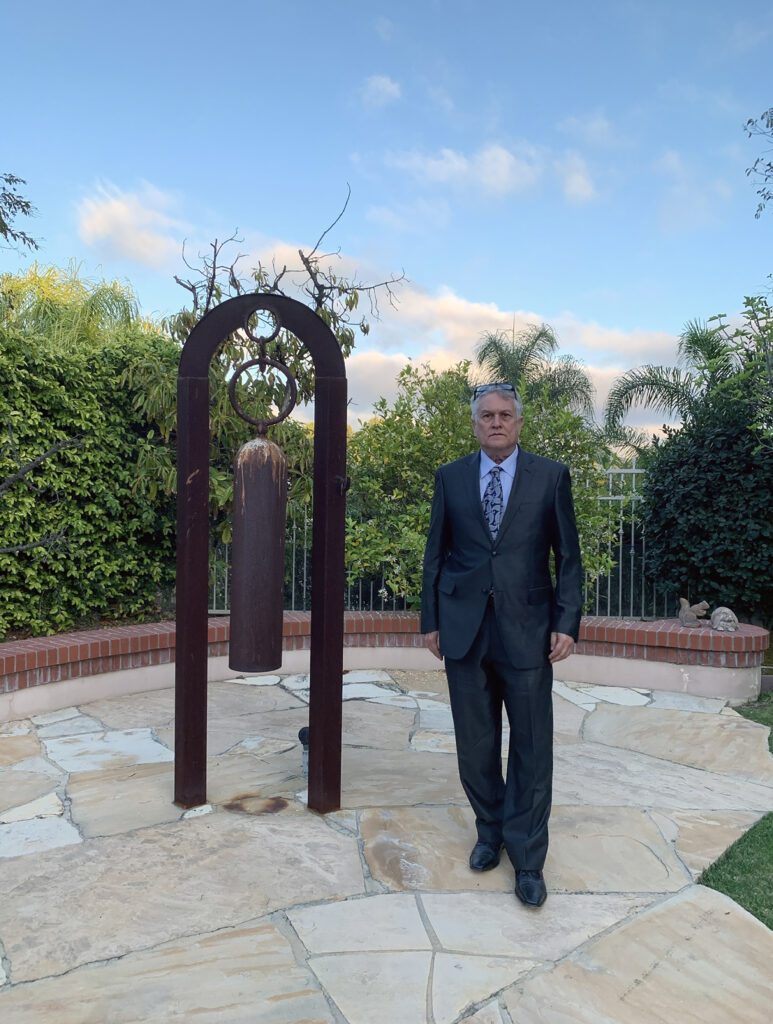 Formal portrait outdoors with decorative garden sculpture