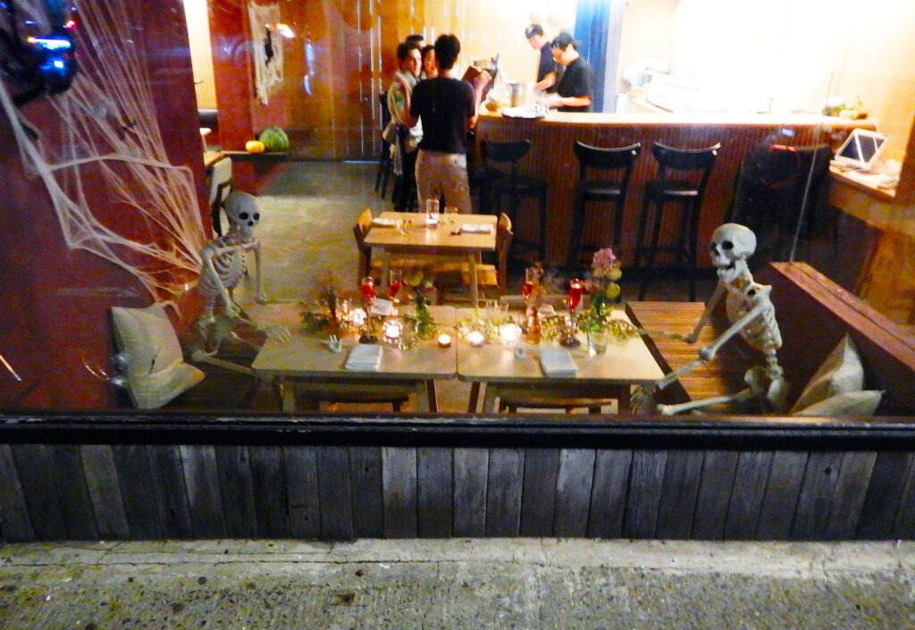 Skeletons seated at candlelit restaurant table