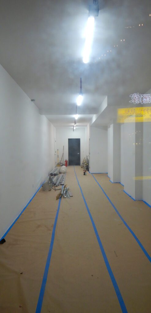 Narrow room under renovation with taped floor