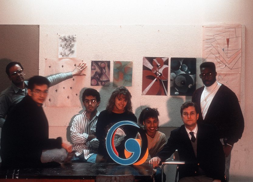 Group of people posing with colorful art